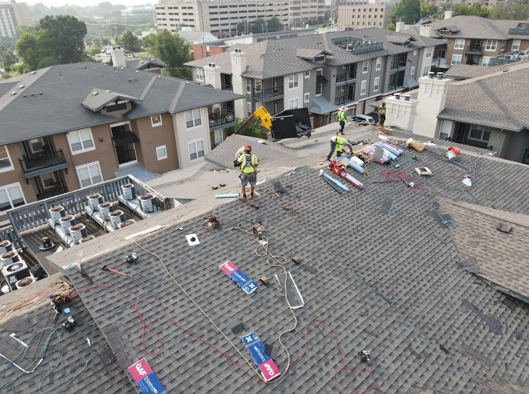 Aerial view of crew re-roofing an apartment complex